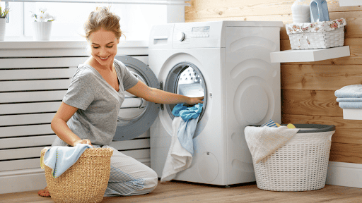 woman putting clothes inside the dryer