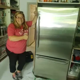 Happy client posing with stainless steel fridge